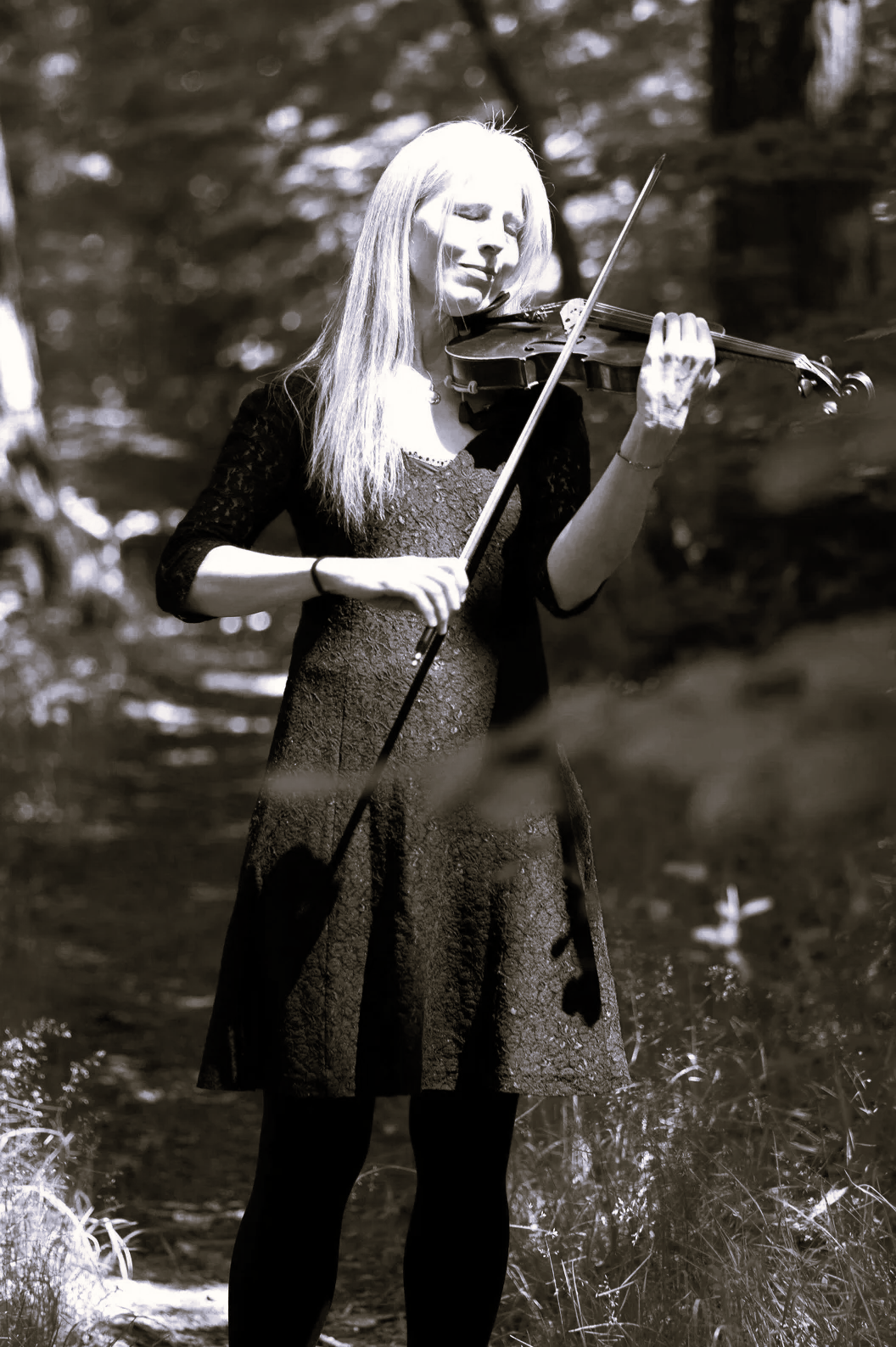 Dr. Nicole Besse (Bai Nike) mit ihrer Violine im Wald.
